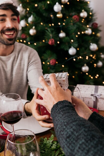 Dando dos regalos a amigo en cena de navidad