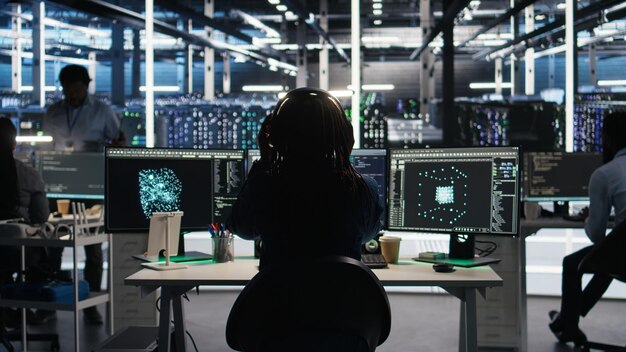 Data center engineer using algorithms to analyze datasets putting on headphones
