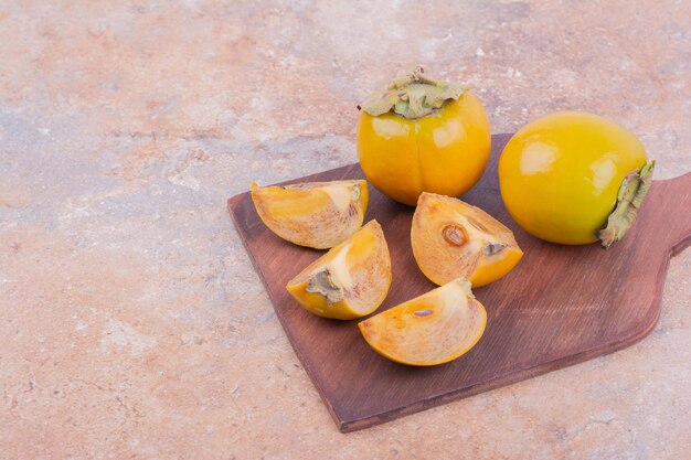 Dátiles de ciruela amarilla aislados en un plato de madera.