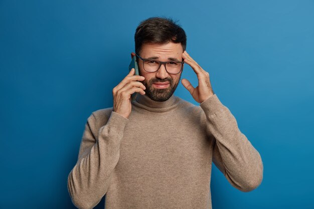 Decepcionado, el hombre afeitado expresa frustración, no puede oír con claridad.