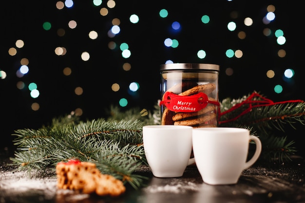 Foto gratuita decoración de año nuevo y navidad. botella con galletas de chocolate y tazas para el té.