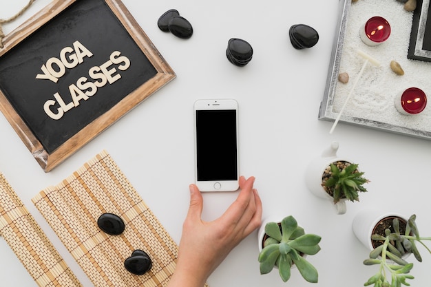 Foto gratuita decoración para clases de yoga con smartphone