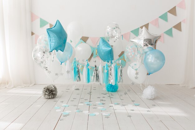 Decoración festiva de fondo para la celebración de cumpleaños con pastel gourmet y globos azules.