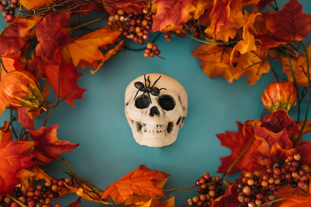 Decoración de halloween con cráneo y hojas de otoño