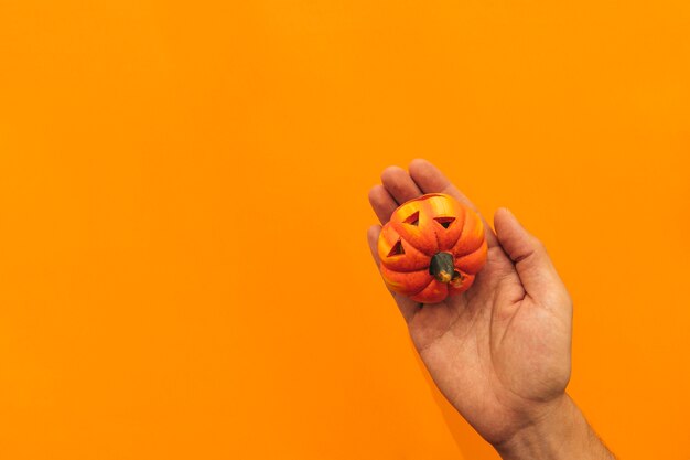 Decoración de halloween con mano sujetando calabaza