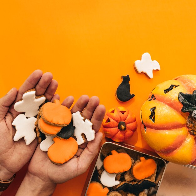 Decoración de halloween con manos sujetando galletas