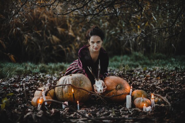 Decoracion de halloween La mujer se parece a una bruja sentada.