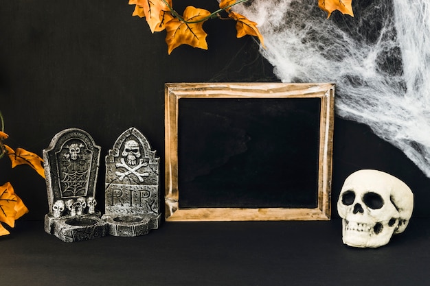 Decoración de halloween con pizarra y objetos espantosos