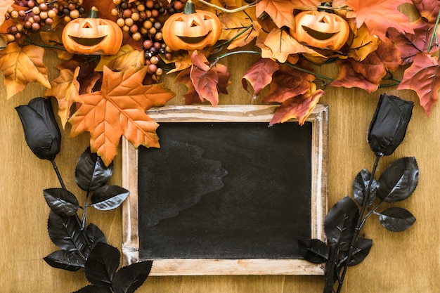 Decoración de halloween con pizarra y rosas negras