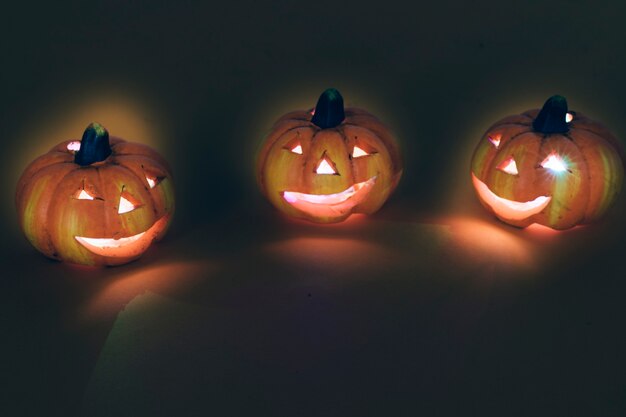 Decoración de halloween con tres calabazas iluminadas