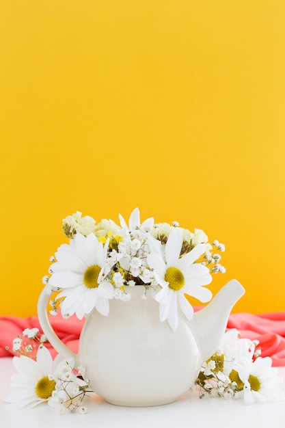 Decoración con margaritas blancas y fondo amarillo.