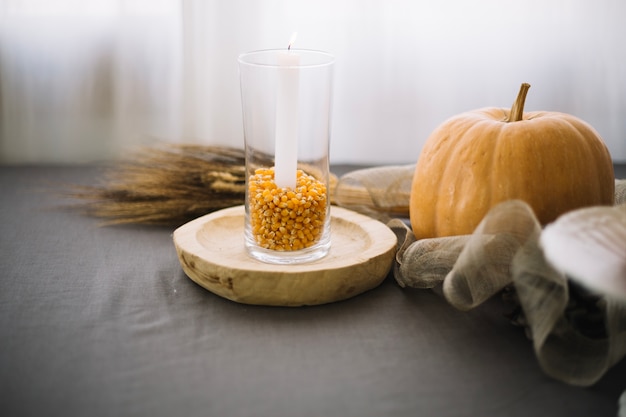 Decoración de mesa de thanksgiving con vaso de semillas