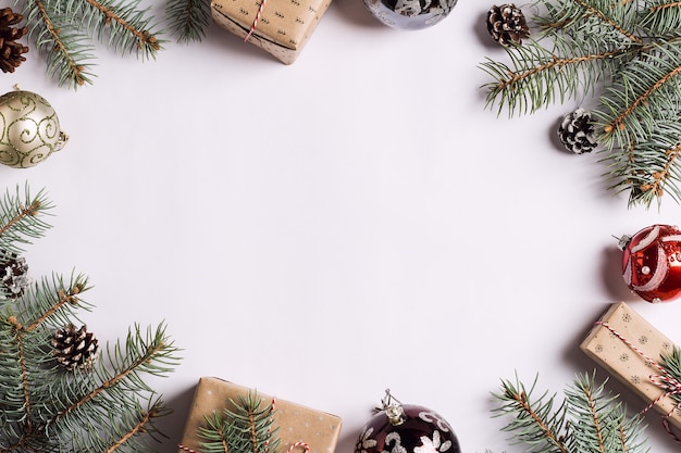 Decoración de Navidad composición caja de regalo conos de pino bola de abeto ramas en mesa festiva blanca