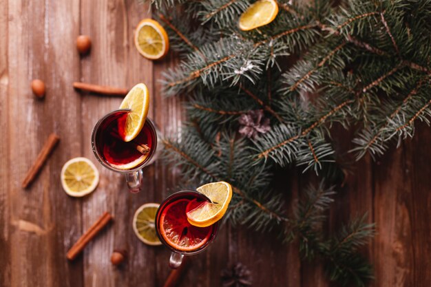 Decoración navideña y año nuevo. Dos copas de vino caliente con naranjas.