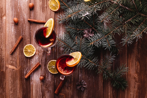 Decoración navideña y año nuevo. Dos copas de vino caliente con naranjas.