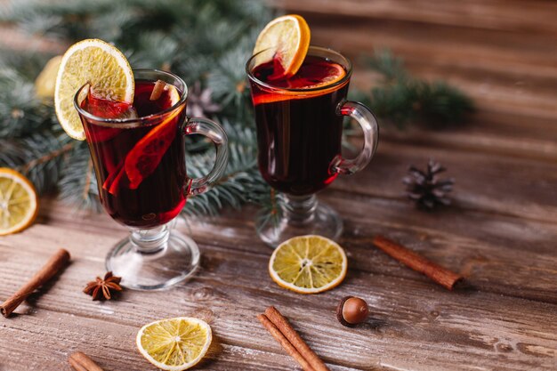 Decoración navideña y año nuevo. Dos copas de vino caliente con naranjas.