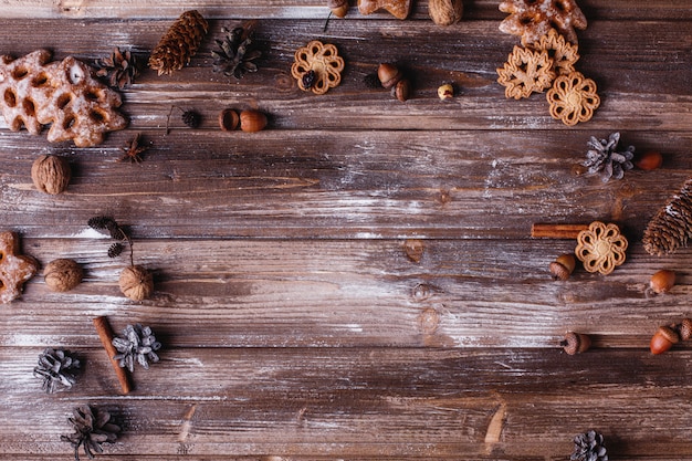 Decoración navideña y lugar para texto. Galletas, ramas de canela y conos forman un círculo.