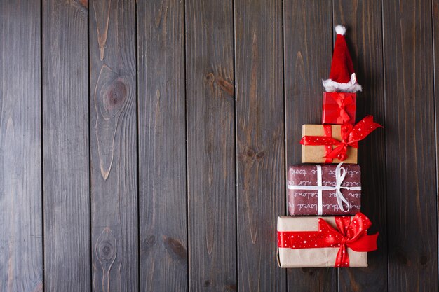 Decoración navideña y lugar para texto. Árbol de año nuevo hecho de regalos se encuentra en una mesa de madera