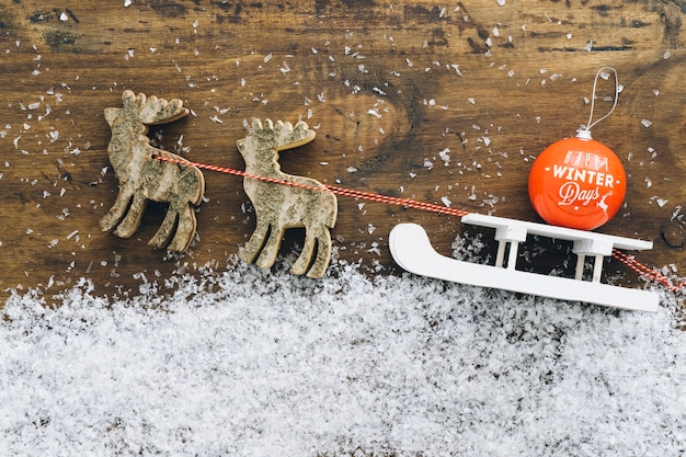 Decoración de nieve de navidad con bola en trineo