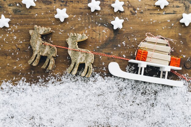 Decoración de nieve de navidad con regalos en trineo