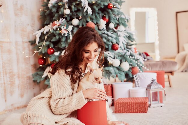 Decoración de vacaciones de invierno. Colores cálidos. Encantadora mujer morena en suéter beige