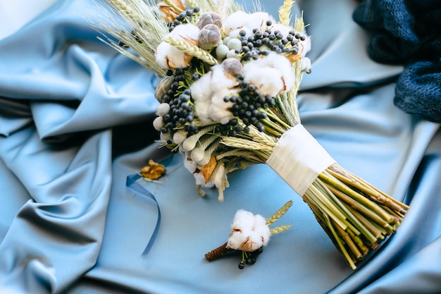 Decoraciones de la boda, flores sobre un fondo de tela azul. Vista de ángulo alto.