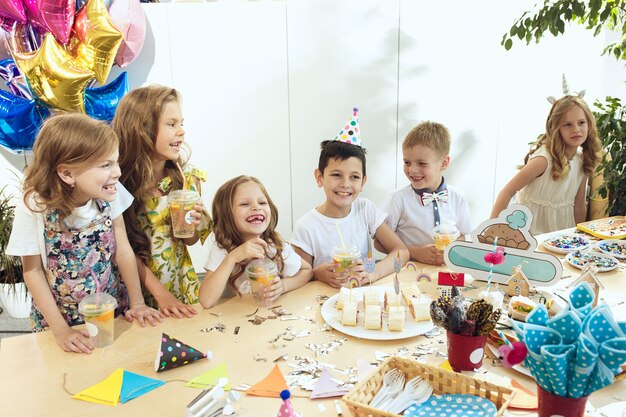 Decoraciones de cumpleaños de niña. Mesa con pasteles, bebidas y artículos de fiesta.