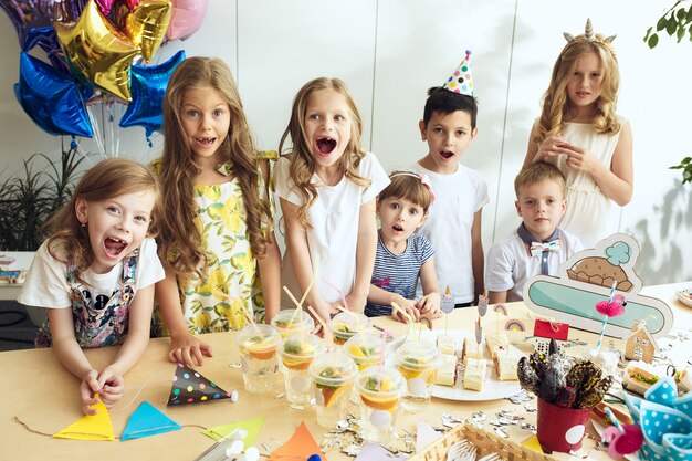 Decoraciones de cumpleaños de niña. Mesa con pasteles, bebidas y artículos de fiesta.