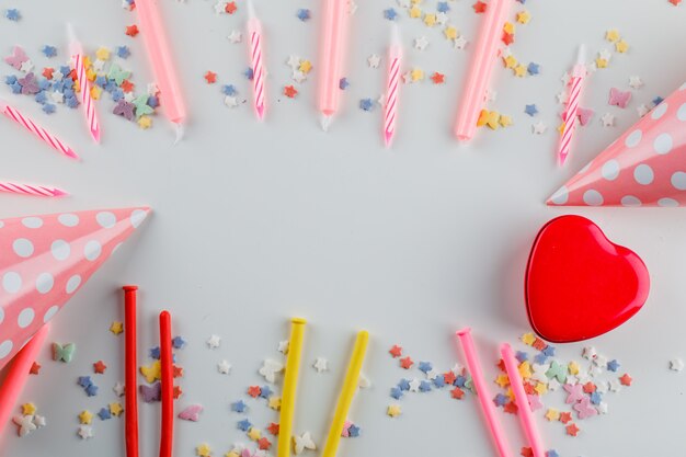 Decoraciones de fiesta con chispas de azúcar, caja de regalo sobre una mesa blanca