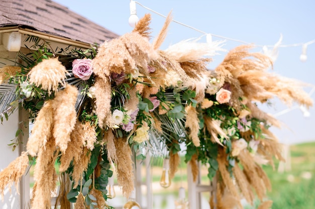 Foto gratuita decoraciones naturales con flores de arco de ceremonia de boda al aire libre