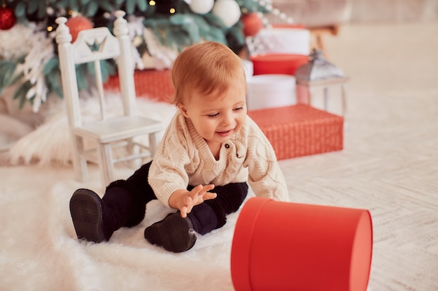 Decoraciones de vacaciones de invierno. colores cálidos. hermosa niña juega con las actuales cajas.