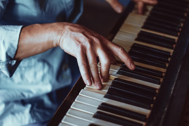 Foto gratuita dedos masculinos tocando las teclas del piano