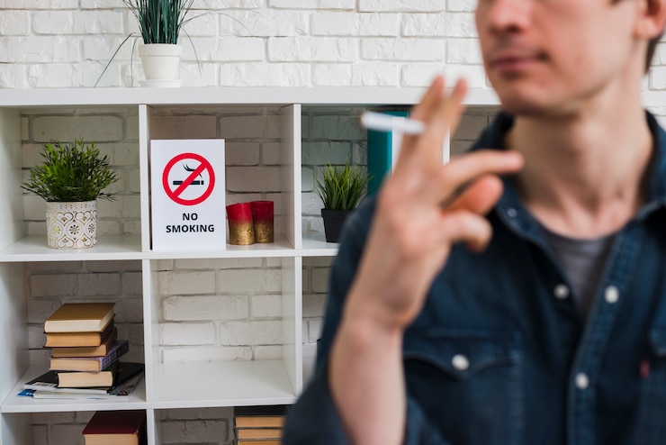 Photo Gratis defocus man with cigarette in front of no smoking poster on shelf