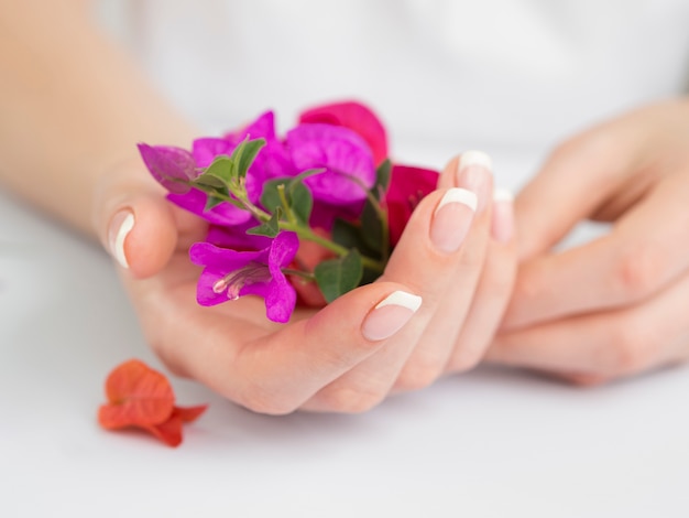 Delicadas manos cuidadas sosteniendo flores