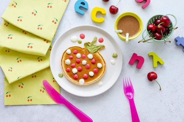 Delicia para el desayuno de panqueques para niños, con forma de fresa divertida