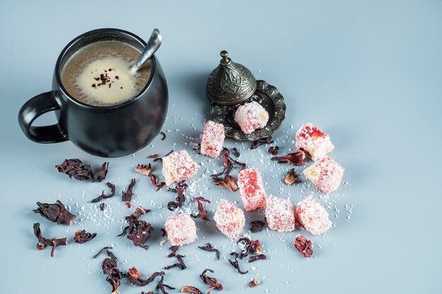 Delicias turcas lokum en un plato metálico con una taza de café