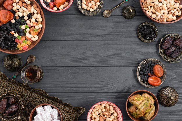 Delicias turcas lukum; baklava; Frutos secos y nueces sobre fondo de madera con espacio en el centro para escribir el texto