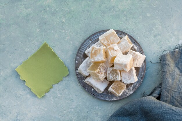 Delicias turcas en plato con papel y tela pequeña.