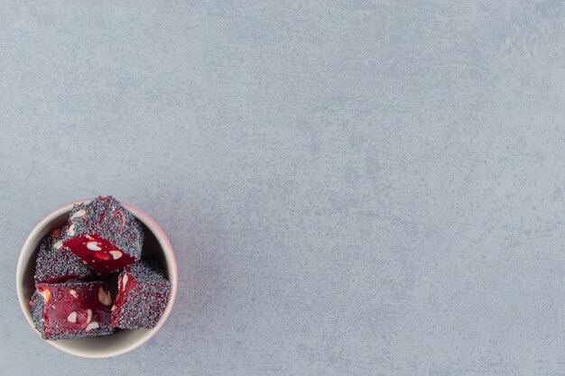 Delicias turcas rojas en el cuenco, sobre el fondo de mármol. Foto de alta calidad