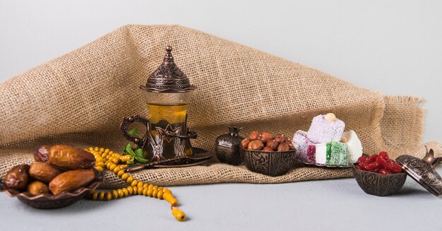 Delicias turcas con vaso de té y dátiles frutales.