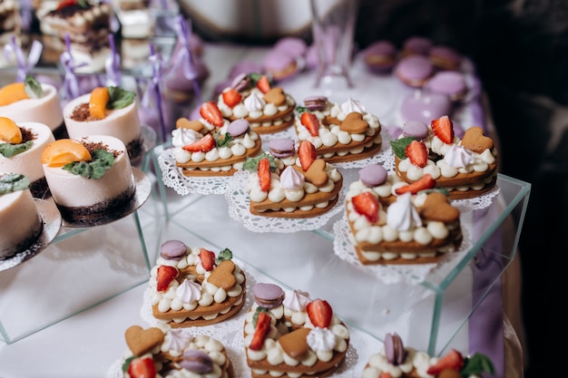 Deliciosa barra de caramelo con postres de mousse y galletas en forma de corazones