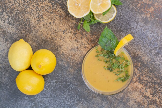 Deliciosa bebida con rodajas de limón y menta en la superficie de mármol