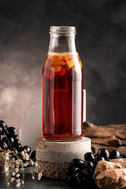 Foto gratuita deliciosa botella de kombucha y arreglo de uvas