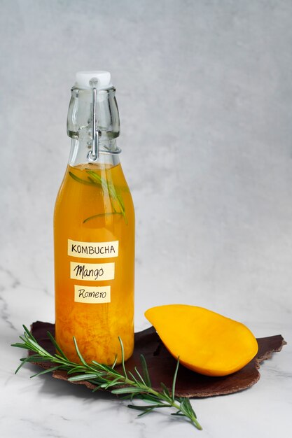 Deliciosa botella de kombucha de mango bodegón