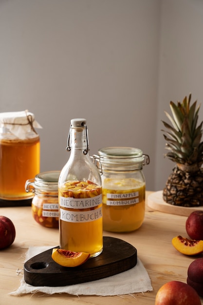 Foto gratuita deliciosa botella de kombucha de nectarina en la mesa