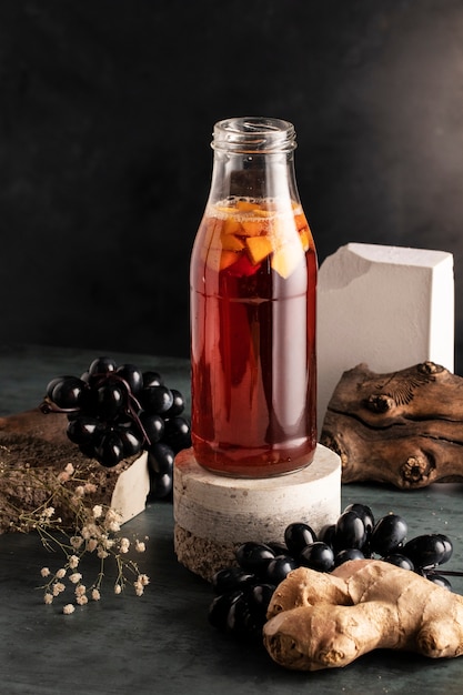 Foto gratuita deliciosa botella de kombucha y uvas