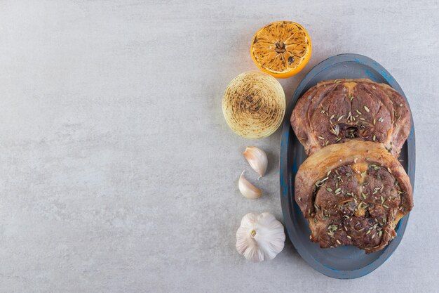 Deliciosa carne con rodajas de limón y fondo de granos de pimienta