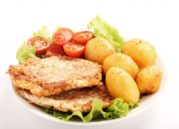 Deliciosa cena con filetes, papas hervidas y ensalada.