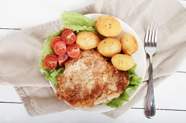 Deliciosa cena con filetes, papas hervidas y ensalada.