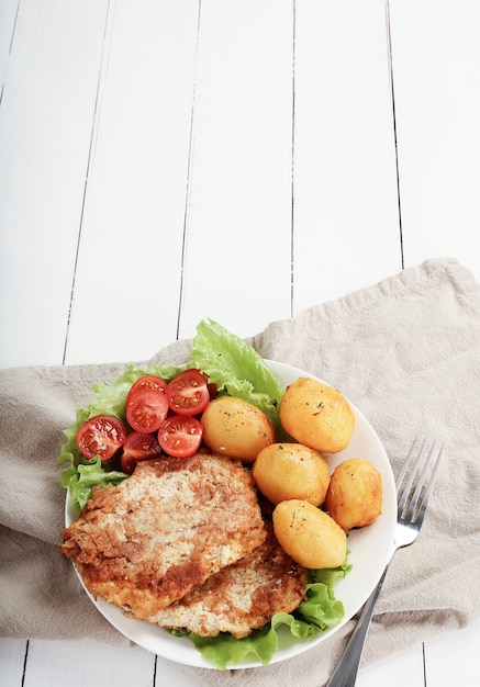 Deliciosa cena con filetes, papas hervidas y ensalada.